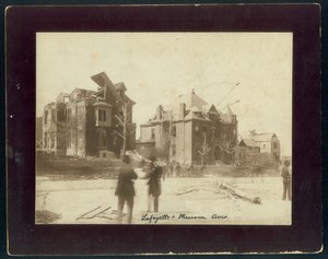 Photo horizontale sépia montrant trois maisons partiellement détruites, des arbres dépouillés et des spectateurs regardant les dégâts causés par une tornade - Unbekannt Unbekannt